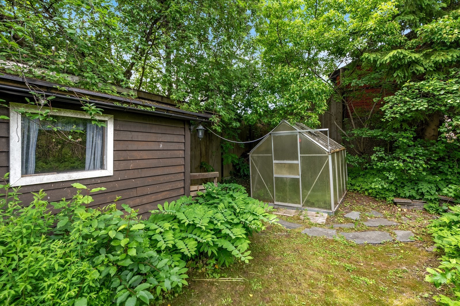 Eiendommen byr på både uthus og drivhus, perfekt for hobbydyrking og praktisk oppbevaring. Galleribilde