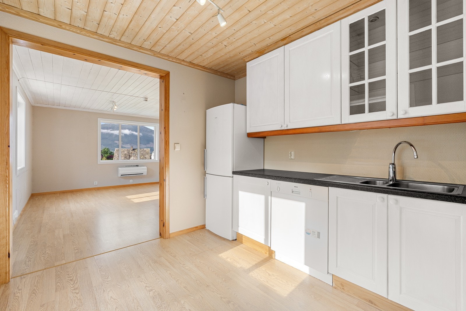 Kjøkkenet består av en eldre, takhøy innredning, utført med hvite profilerte fronter og bekeplate av laminat. Galleribilde