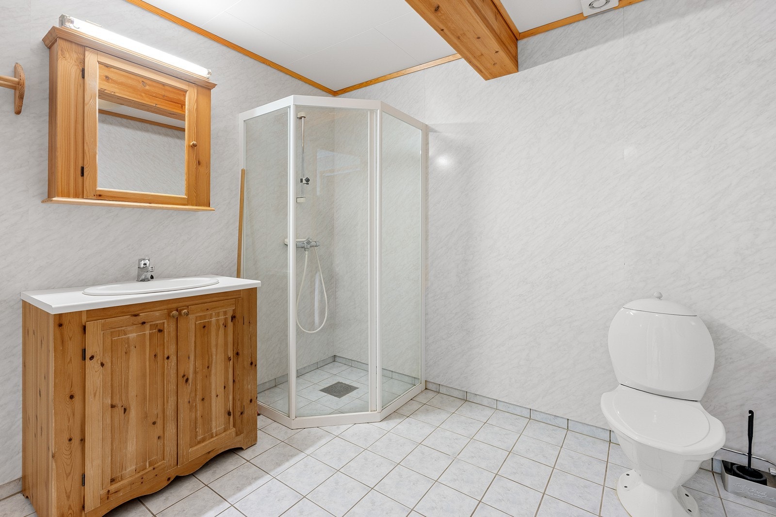 Badet er utført med fliser på gulv og våtromsplater på veggflater. Galleribilde