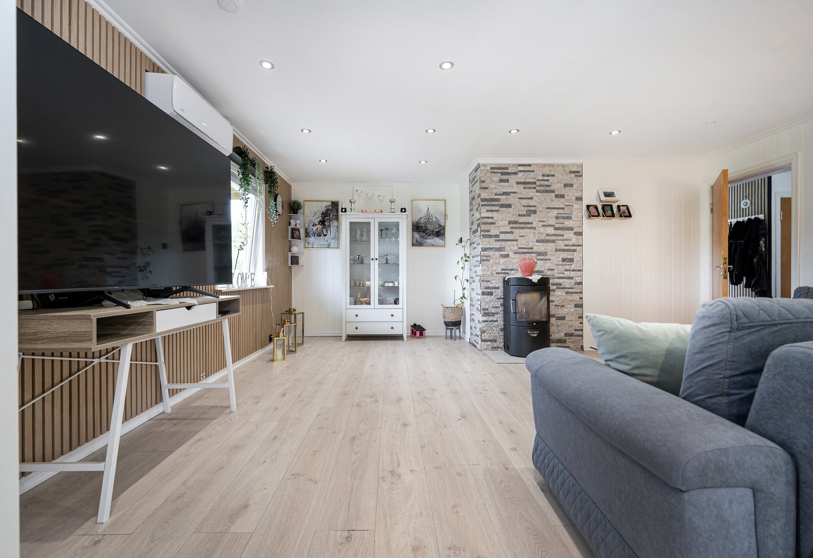 Stuen har god plass til sofagruppe og er utstyrt med et ildsted fra byggeåret. Galleribilde