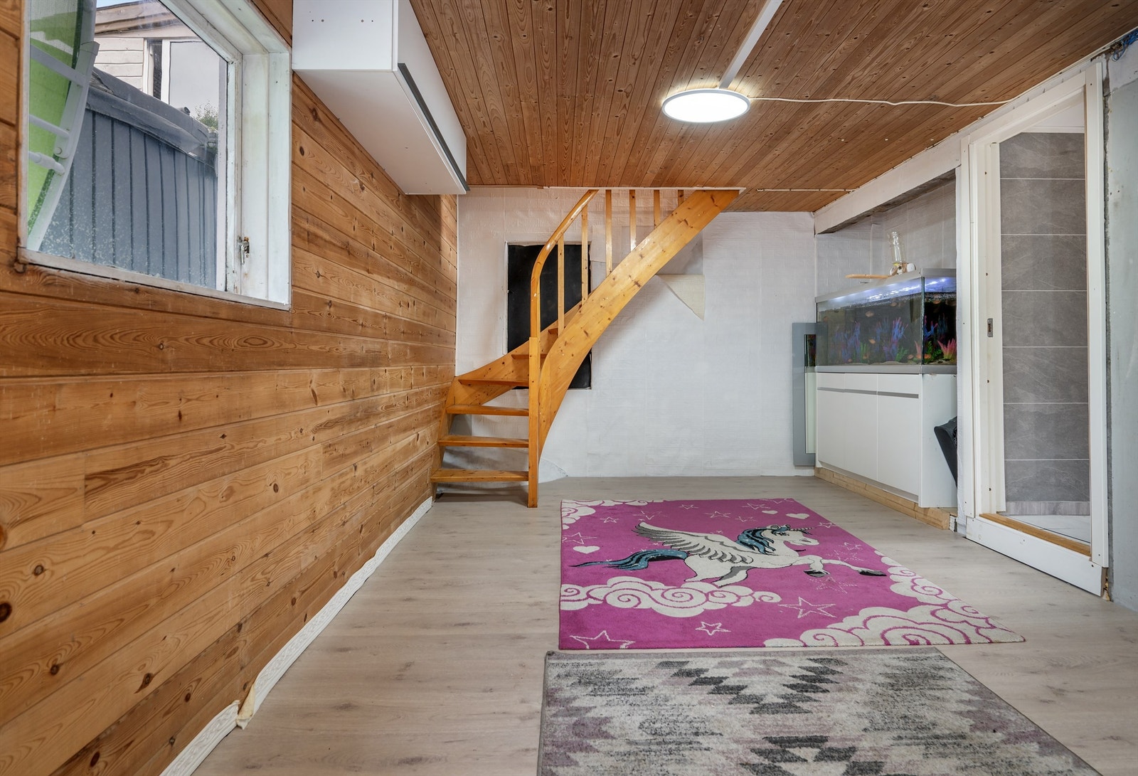 Kjellerstue med lakkert trapp og vegger med panel. Galleribilde