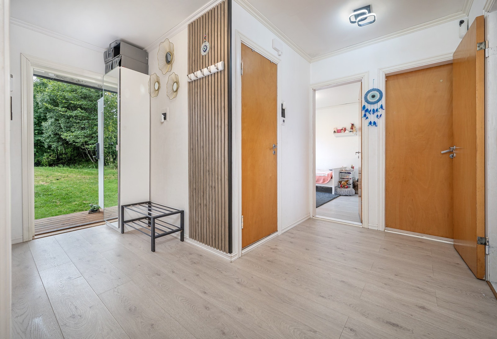 Entréen ønsker velkommen inn i boligens hovedetasje med gjennomgående laminatgulv. Galleribilde