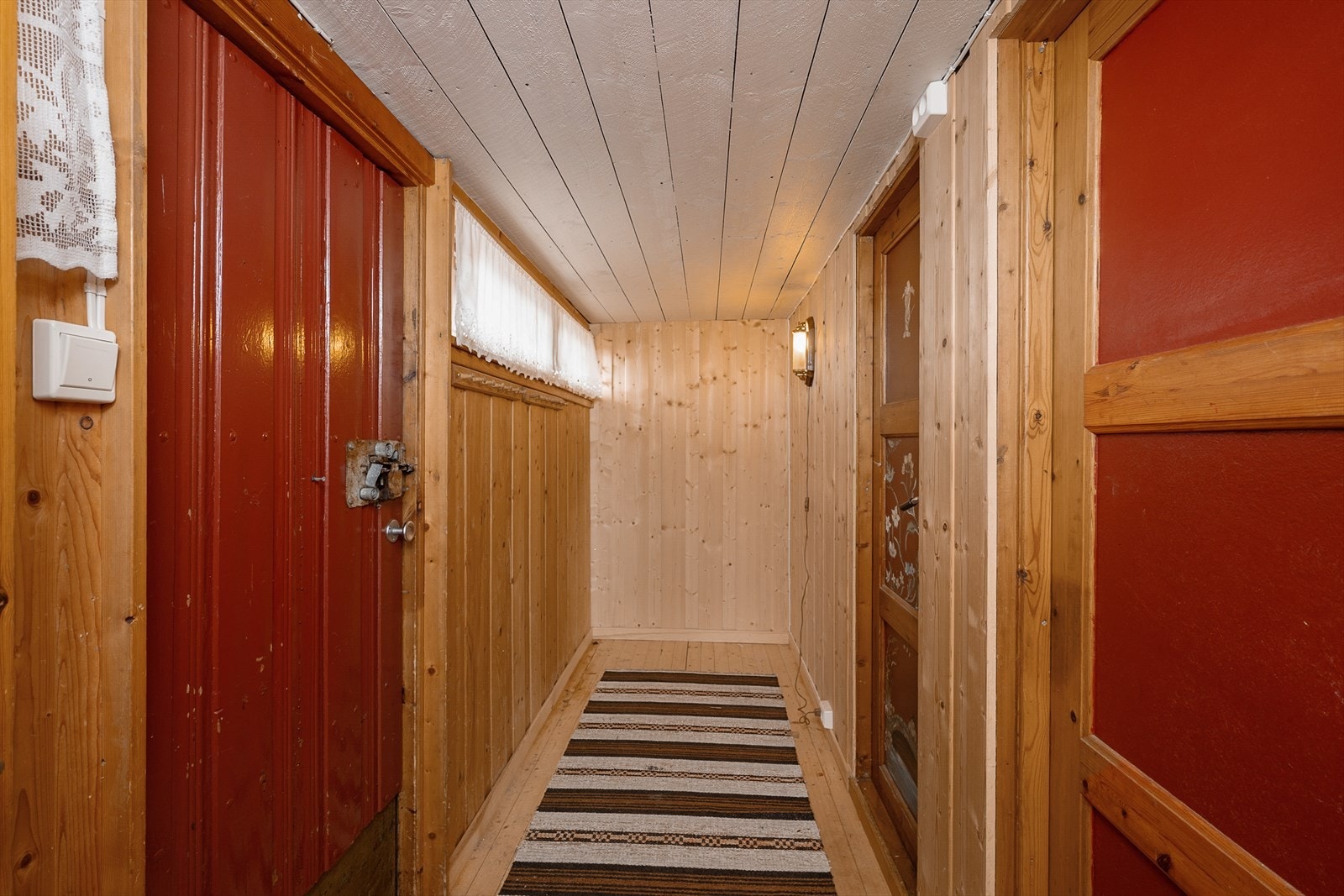 Entré med plass til yttertøy. Lakkerte tregulv og panel på vegger og i tak. Galleribilde