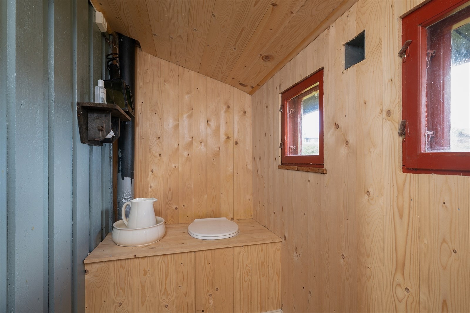 Tradisjonell utedo i egen del av bygget, med adkomst fra gangen. Galleribilde