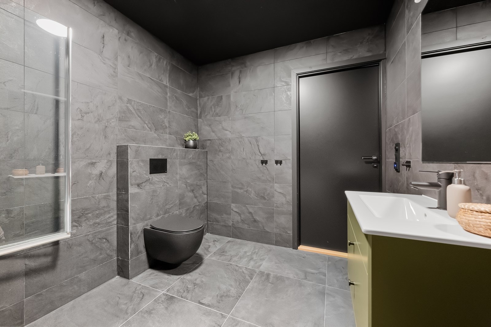 Også dette badet har fliser, gulvvarme og vegghengt toalett. Galleribilde