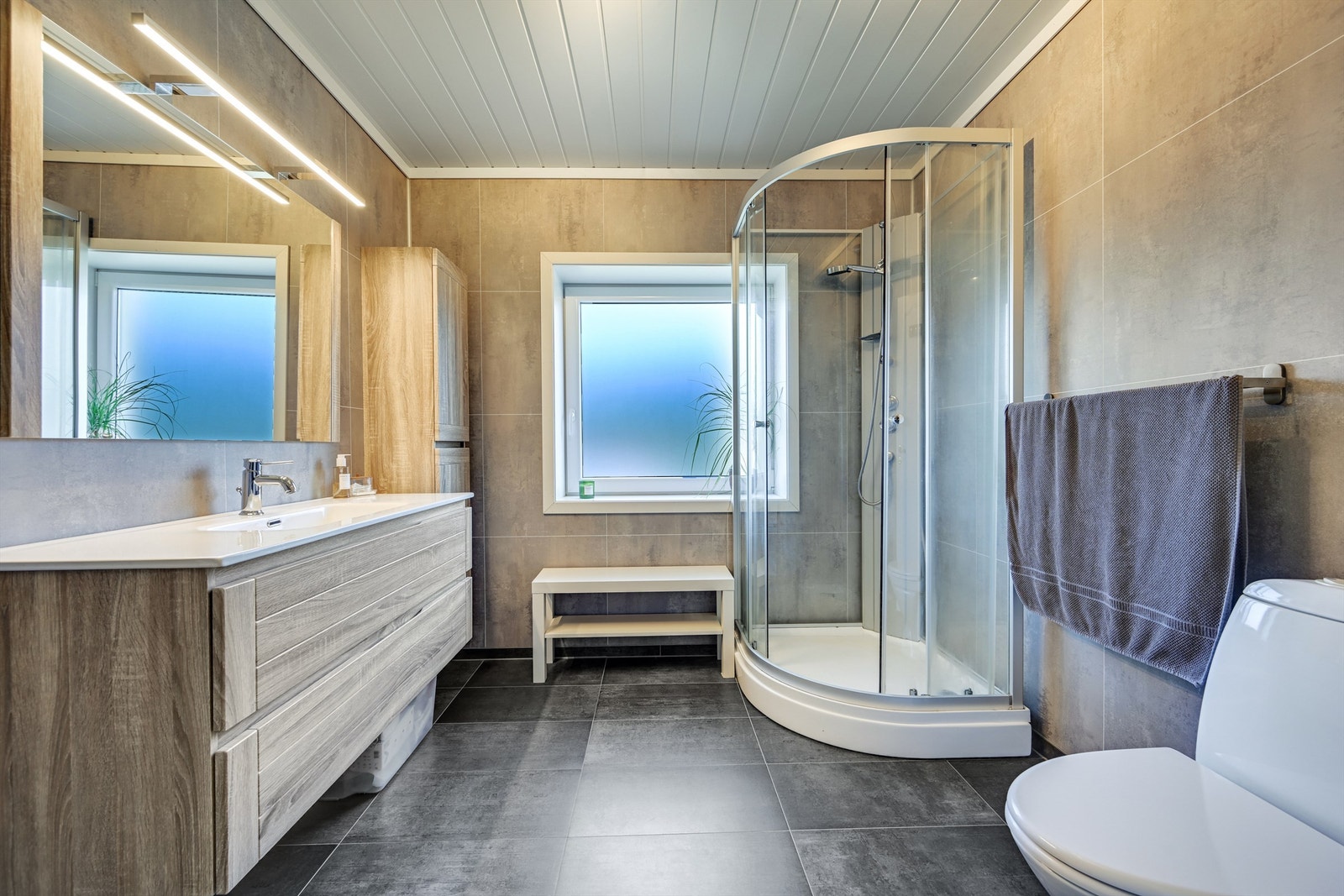 Badet har elektrisk gulvvarme og er innredet med dusjkabinett og en romslig servantinnredning. Galleribilde