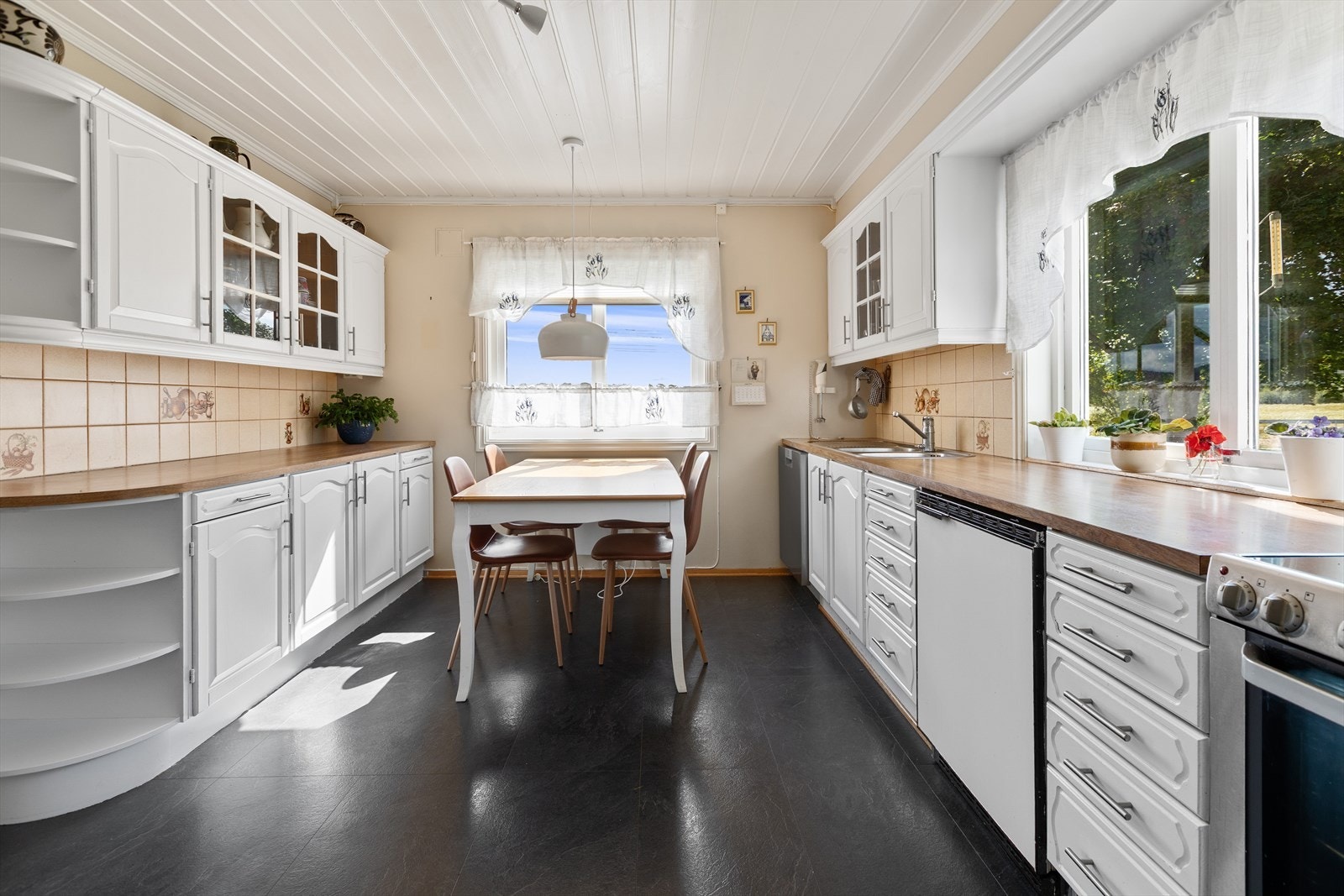 Kjøkken med profilerte fronter og god plass til spisebord. Galleribilde