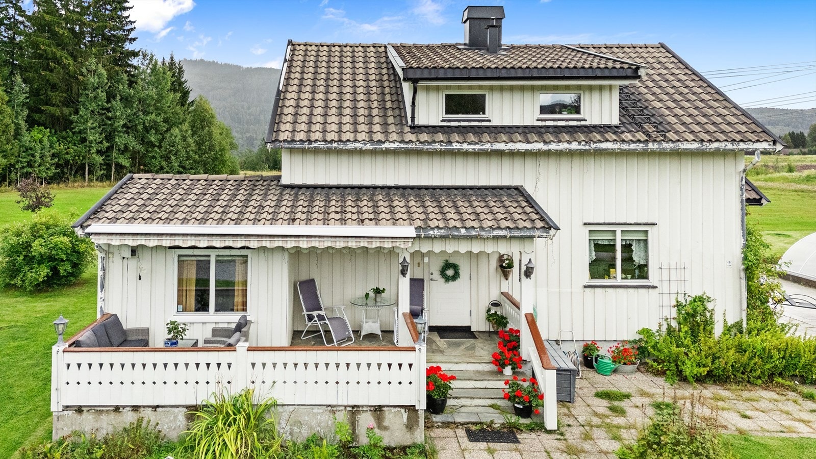 Fasaden har stående, hvitmalt kledning. Galleribilde
