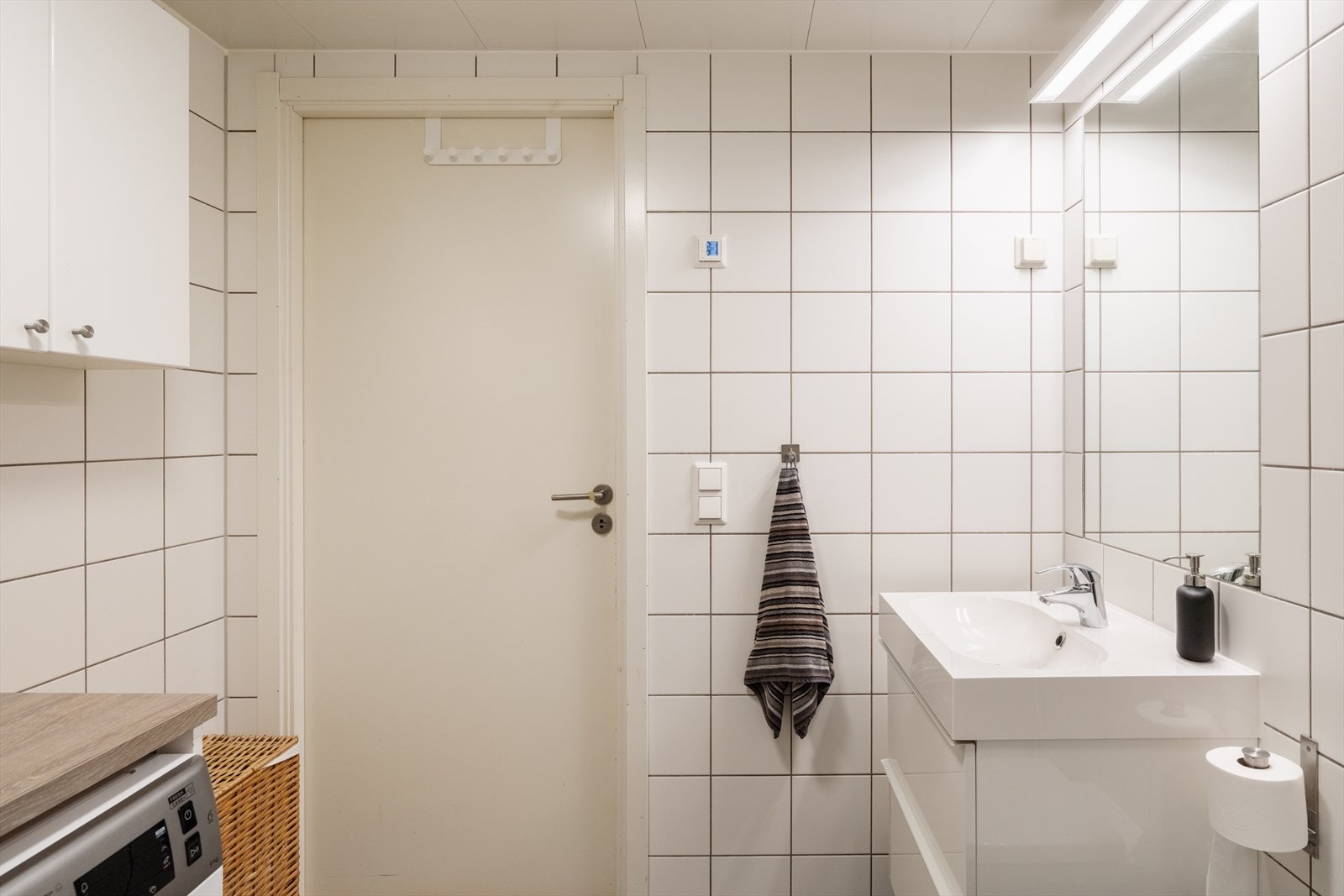 Baderomsinnredning med heldekkende servant og speil med belysning. Galleribilde