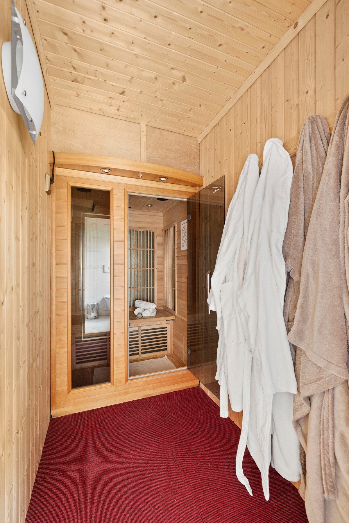 Innbydende badstue med trepanel og lun atmosfære, tilknyttet baderommet. Galleribilde