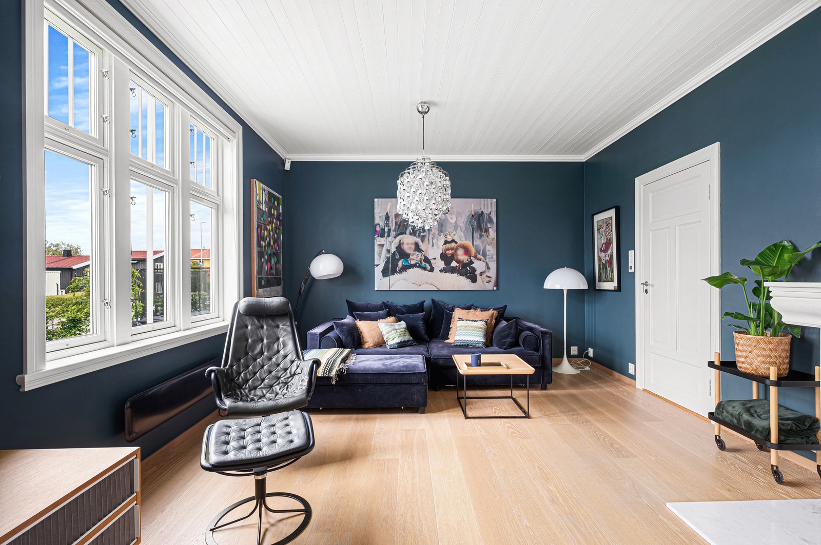 Stilren stue med gode møbleringsmuligheter og store vindusflater som slipper inn rikelig av natulig lys. Galleribilde