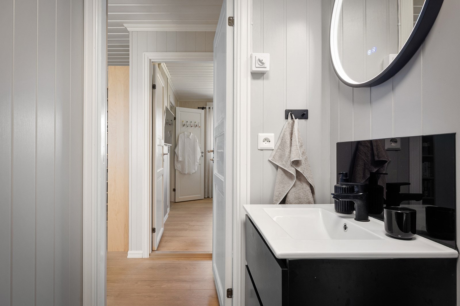 På motsatt side av gangen finner du badet som ble pusset opp i 2026 med nytt gulv, vegger og innredning og med et fint dusjkabinett. Den tøffe svarte fargen går igjen fra kjøkkenet. Galleribilde