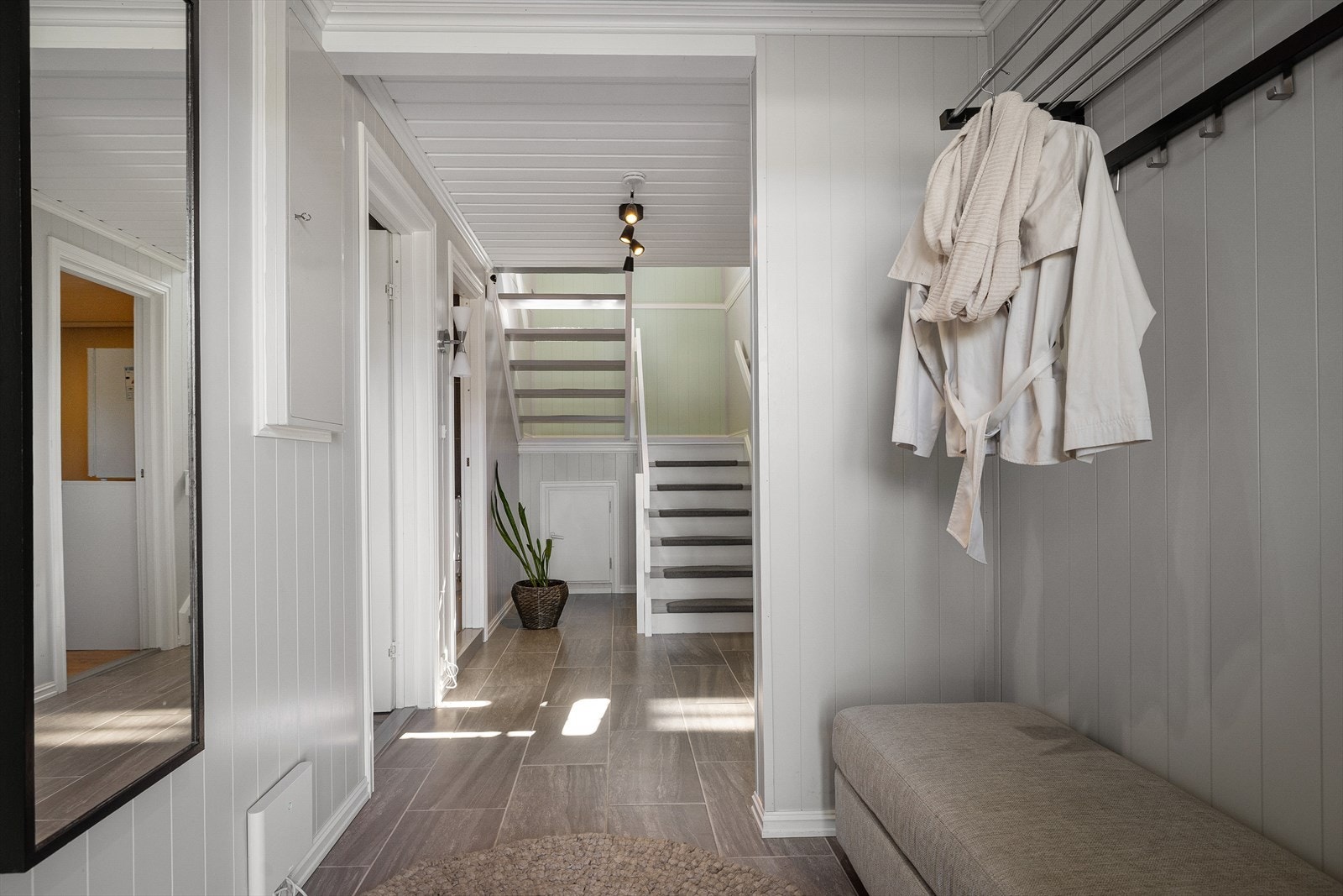 Du kommer inn i underetasjen. Flislagt, lys og åpen. Entreen gir adkomst til to soverom, bod, bad og vaskerom før den løfter seg i en halvsvingtrapp i enden og tar deg opp til første etasje. Galleribilde