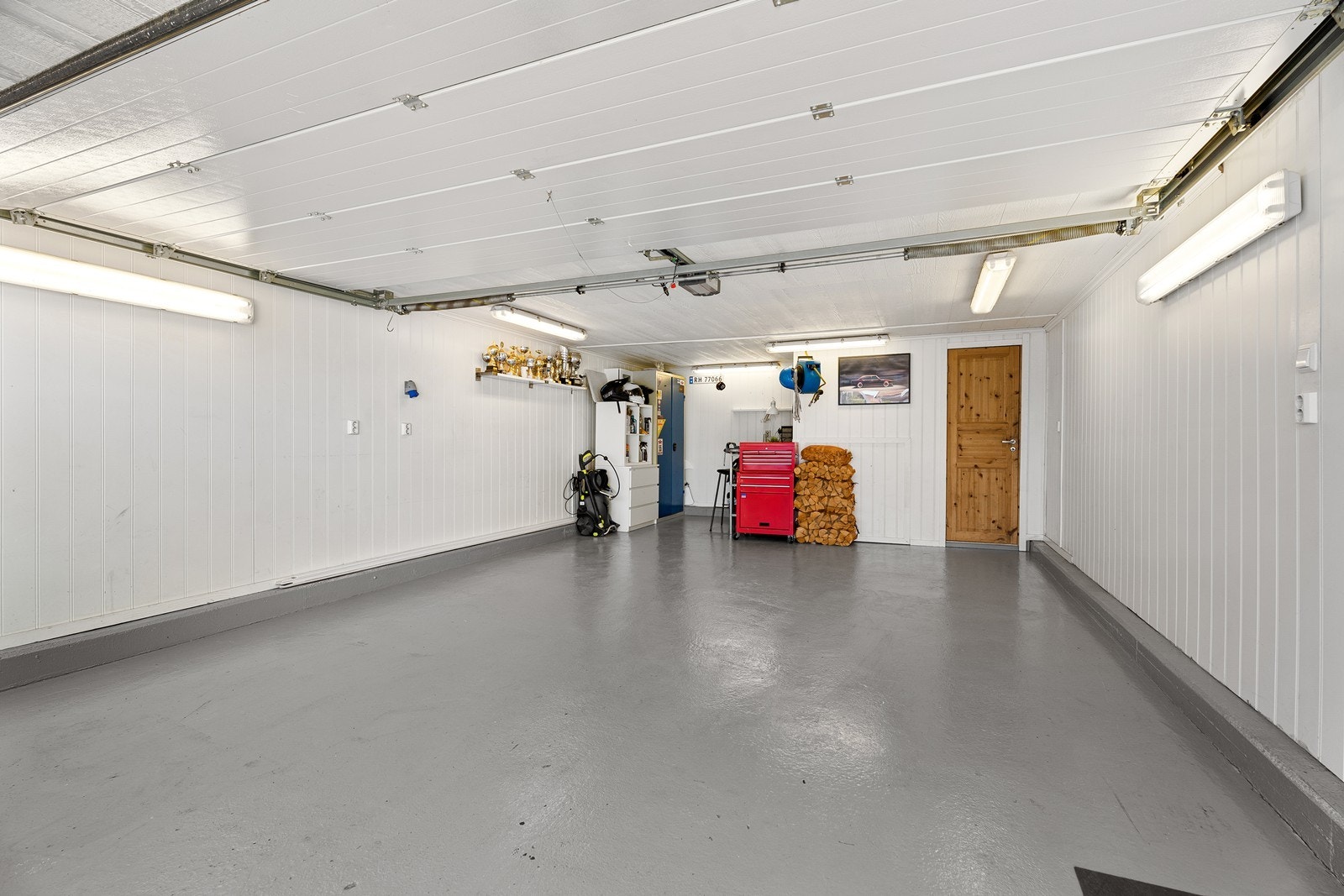 Dobbelgarasje med dør som fører opp til loft som brukes til lagring. Galleribilde