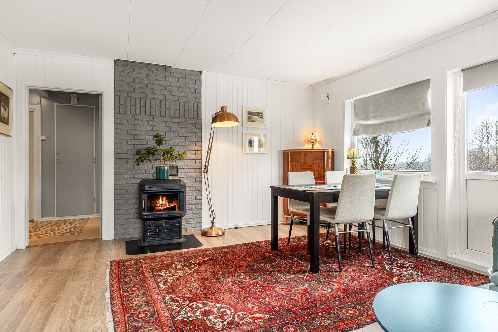 Stuen har plass til spisestue ved vinduet og en vedovn, for ekstra varme på kalde dager - Utgang til solrik veranda Galleribilde