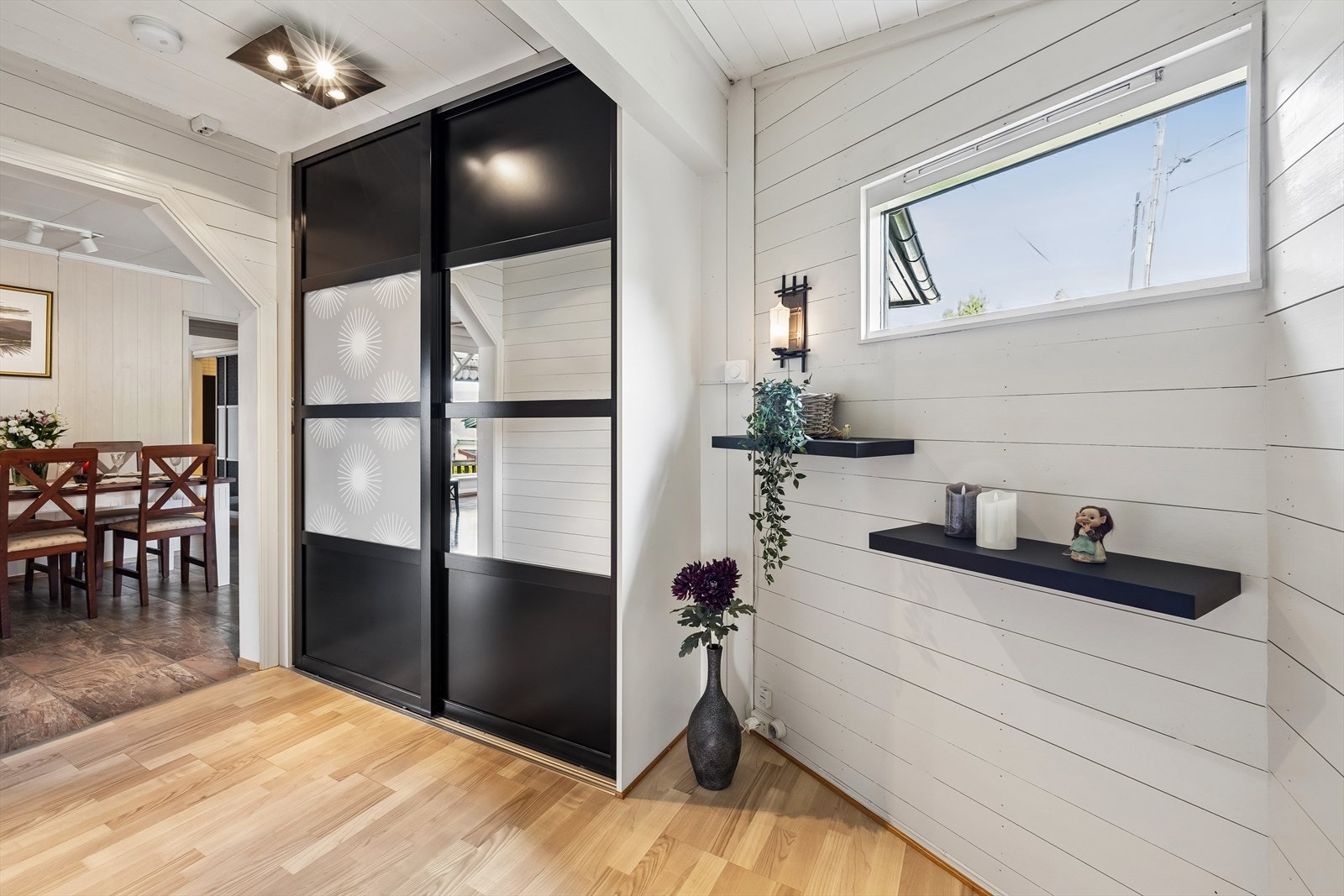 Romslig entré med garderobeskap med skyvedører. Galleribilde