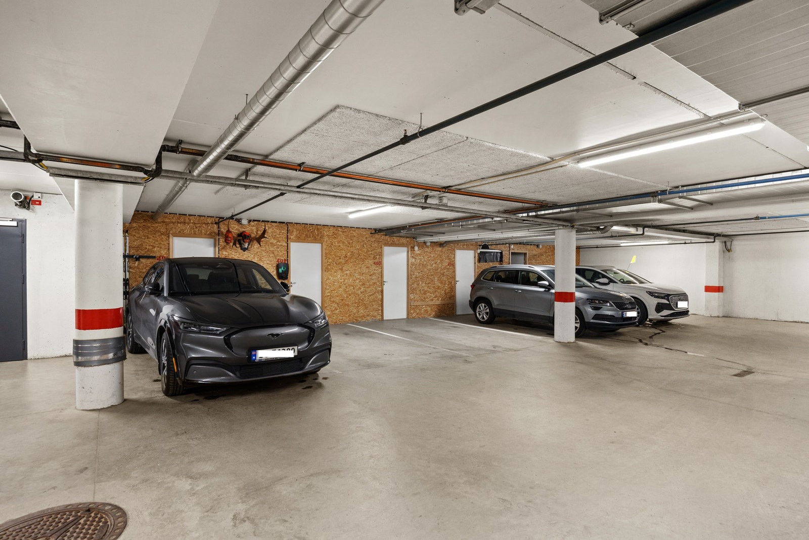 Parkeringsplass i garasje med elbillader. Galleribilde