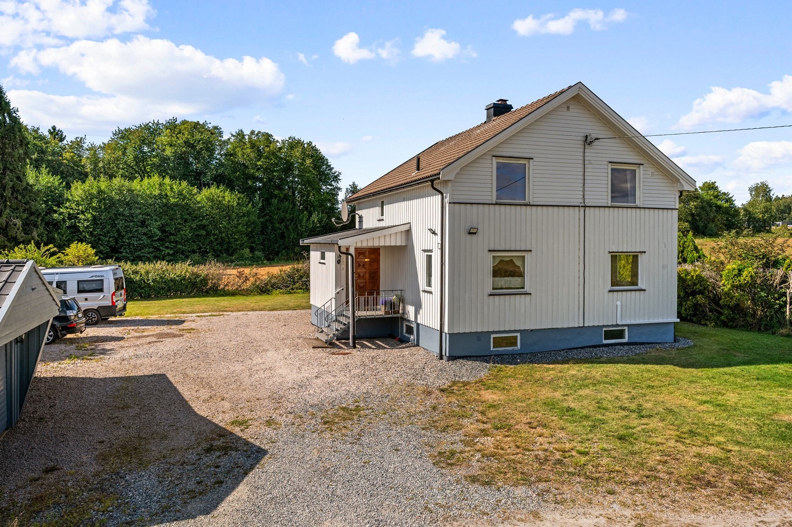 Enebolig fra 1952 over tre plan med stor, gruset gårdsplass. Galleribilde