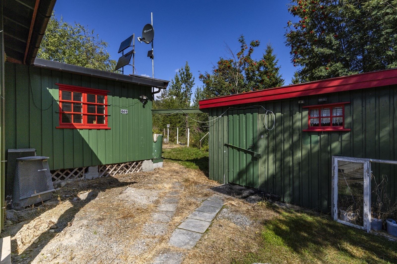 Hytta og uthuset er plassert på en lett opparbeidet tomt med naturlig fall. Galleribilde