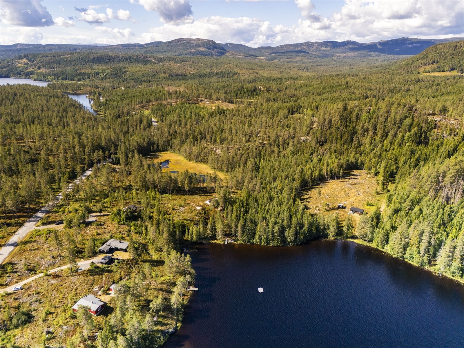 Eiendommen ligger i et etablert hytteområde omgitt av skog og vann. Galleribilde