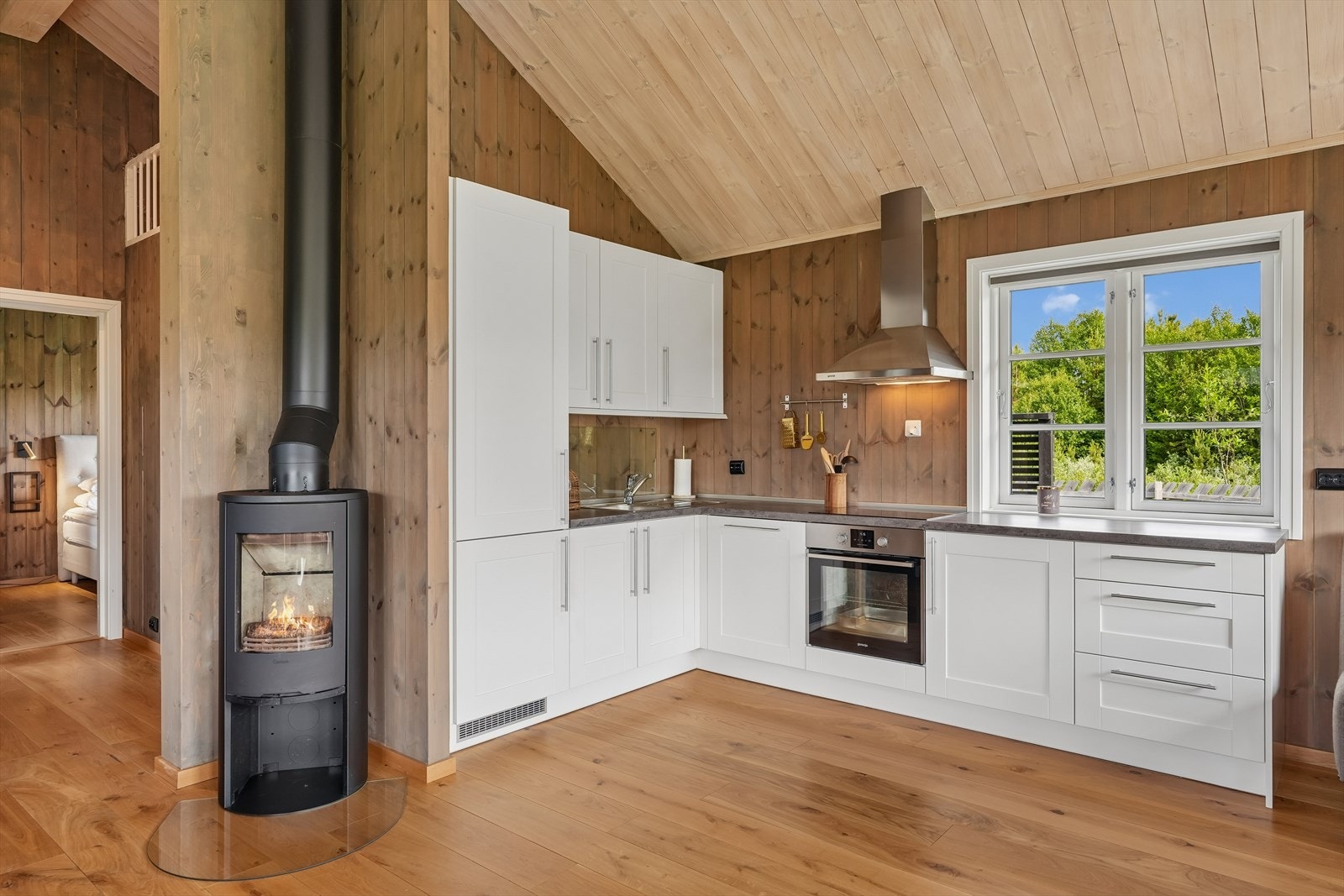 Kjøkkenet har lys og pen innredning med benke- og overskap i laminerte trefiberplater, malte MDF-fronter med profil og laminatbenkeplate med nedfelt oppvaskkum i rustfritt stål. Galleribilde