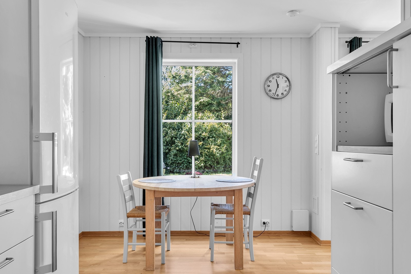Spiseplassen på kjøkkenet er lyst og innbydende, med utsikt over det grønne utenfor - perfekt for en rolig frokost eller en hyggelig lunsj. Galleribilde
