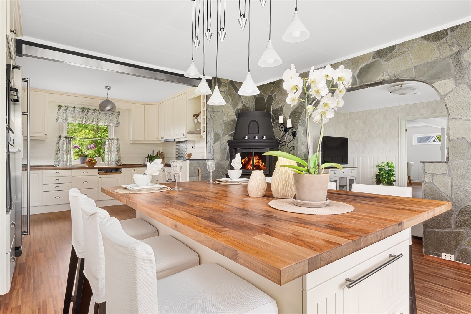 Elegant og klassisk kjøkkeninnredning fra "Mørekjøkken" med lyse profilerte fronter og benkeplate av laminat som bærer et harmonisk samspill mellom eleganse og funksjonalitet. Galleribilde