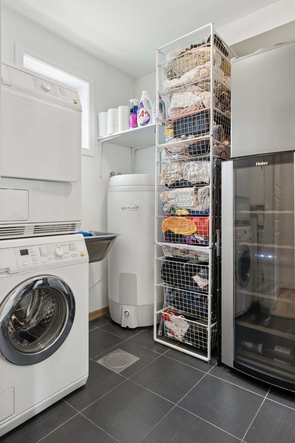 Praktisk vaskerom med opplegg for vaskemaskin og en 200-liters varmtvannstank. Galleribilde