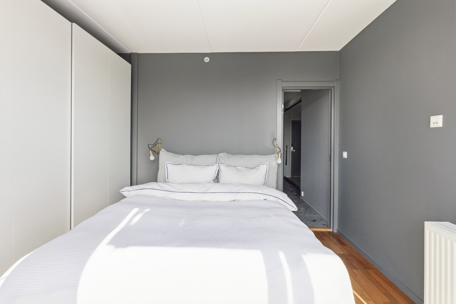 Rommet er delikat innredet med skyvedørsgarderobe, plass til dobbeltseng og vegghengte nattbord. Galleribilde