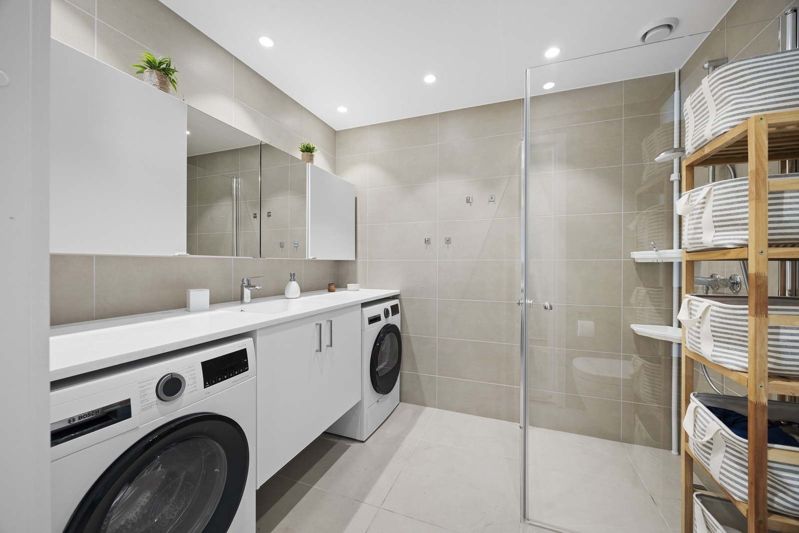 Badet har gulvvarme, opplegg for vaskemaskin og innredning fra Strai. Galleribilde