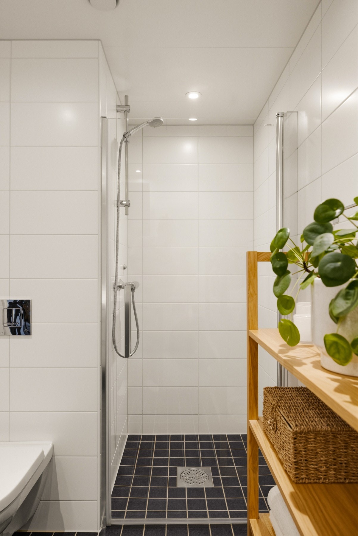 Dusjnisjen med svingbar glassdør gir badet et moderne og ryddig uttrykk, samtidig som løsningen er både plassbesparende og funksjonell. Galleribilde