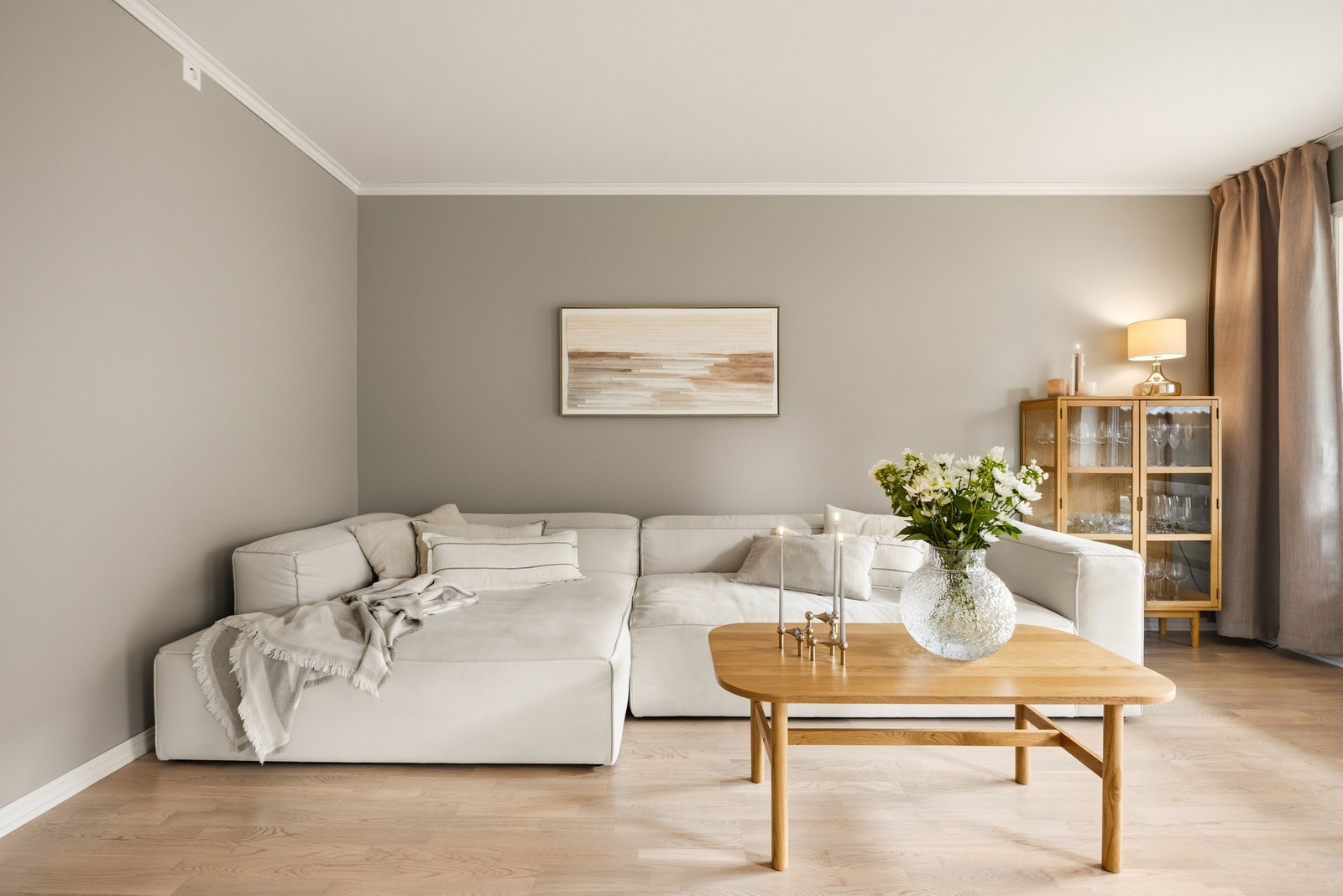 Stuen har god plass til en komfortabel sofagruppe og øvrig møblement, og de tidsriktige fargetonene gir rommet et gjennomført og moderne uttrykk. Galleribilde