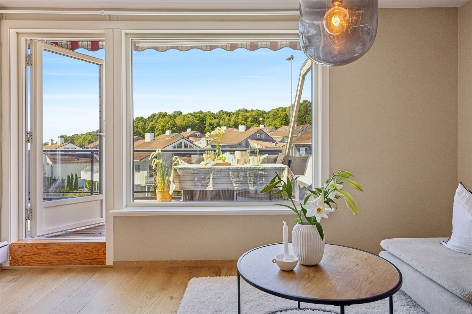 Fra stuen leder store vindusflater ut til en romslig, solrik balkong. Galleribilde
