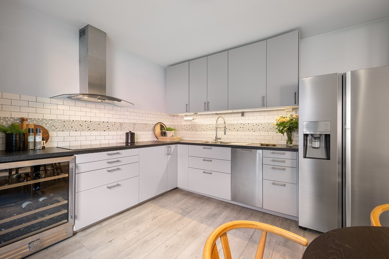Kjøkkenet har en funksjonell og praktisk utforming med en lekker kjøkkeninnredning fra 2015, med moderne, glatte fronter og laminert benkeplate. Galleribilde