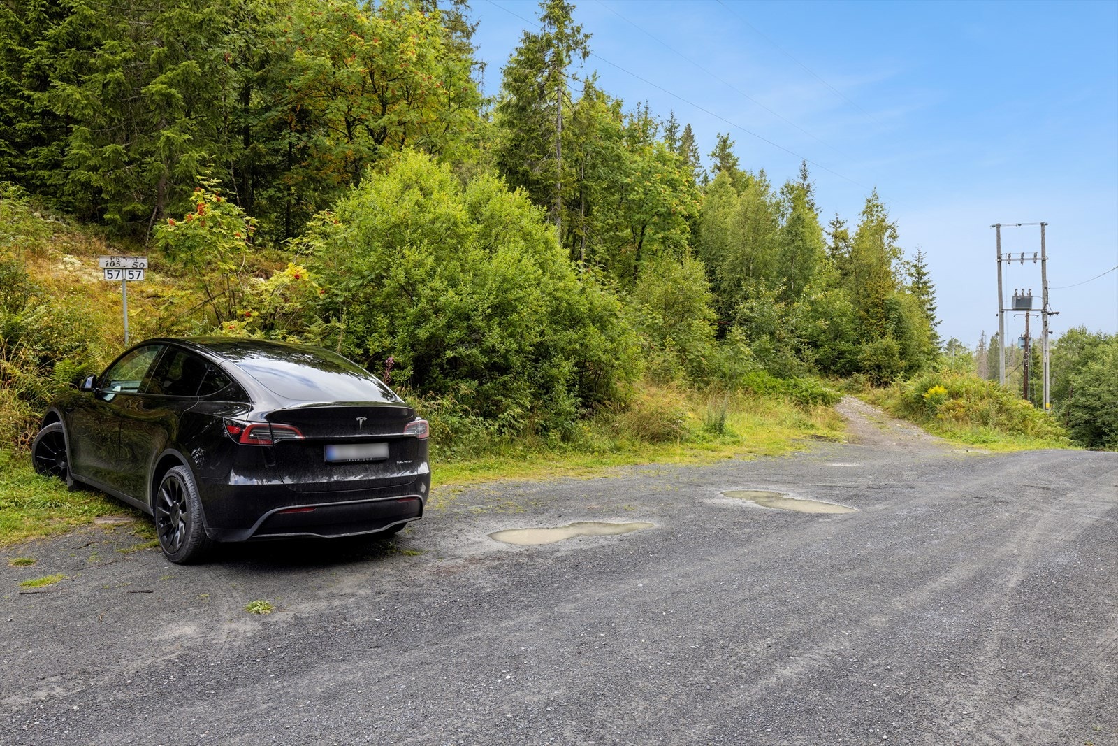 Du har egen parkeringsplass for to biler, veien opp til hytta går inn til venstre bak bilen Galleribilde