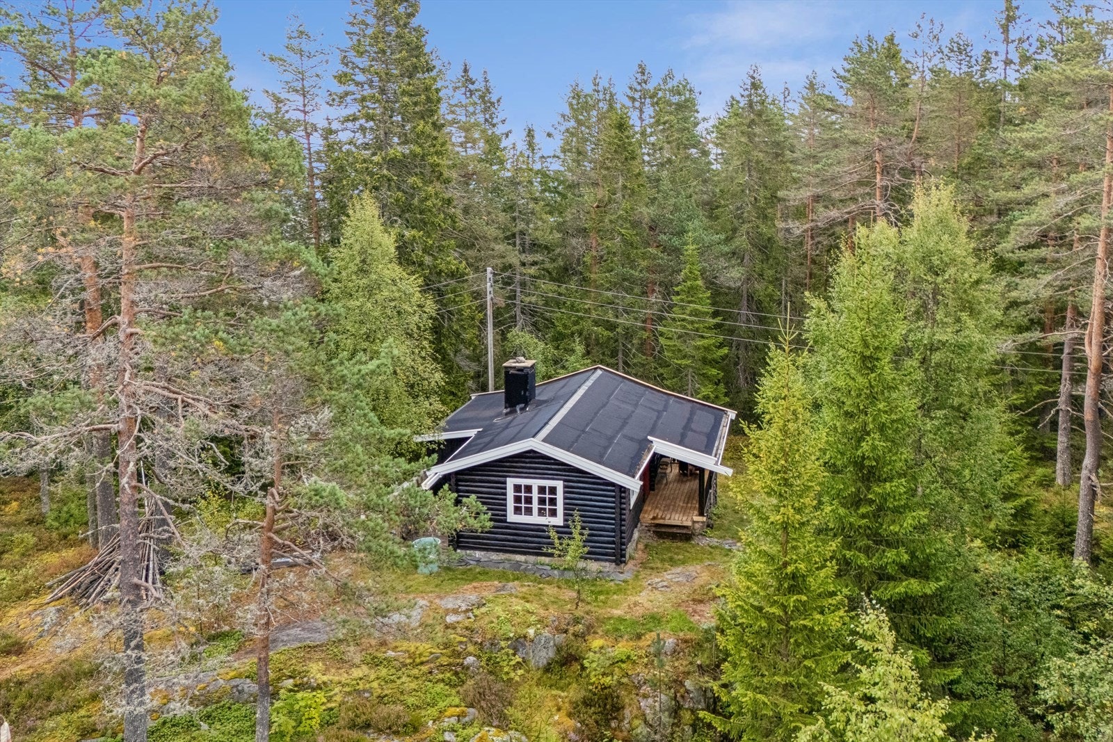 Hytta ligger fint plassert på et lite høydedrag i terrenget Galleribilde