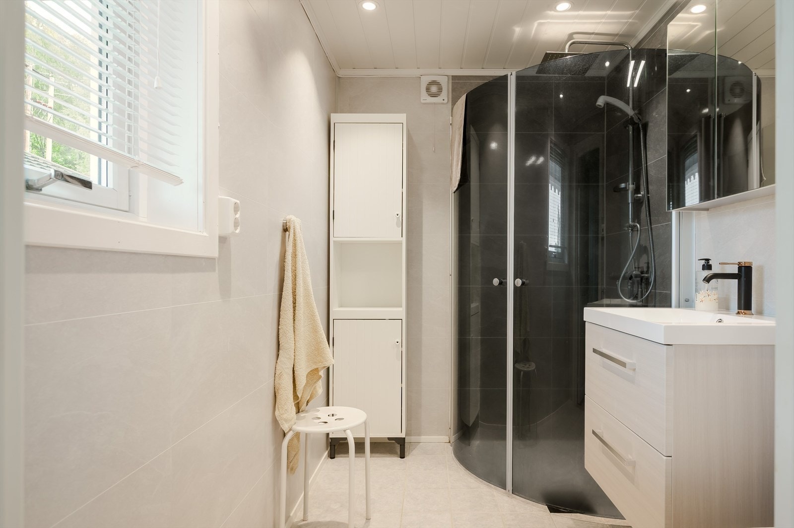 Badet inneholder hjørnedusj, toalett, speilskap og servant. Galleribilde