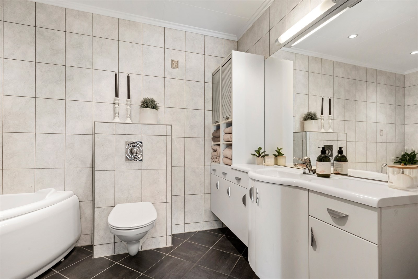Badet er heilflisa og romsleg. Her er det varmekablar i golvet og downlights i himlinga. Galleribilde