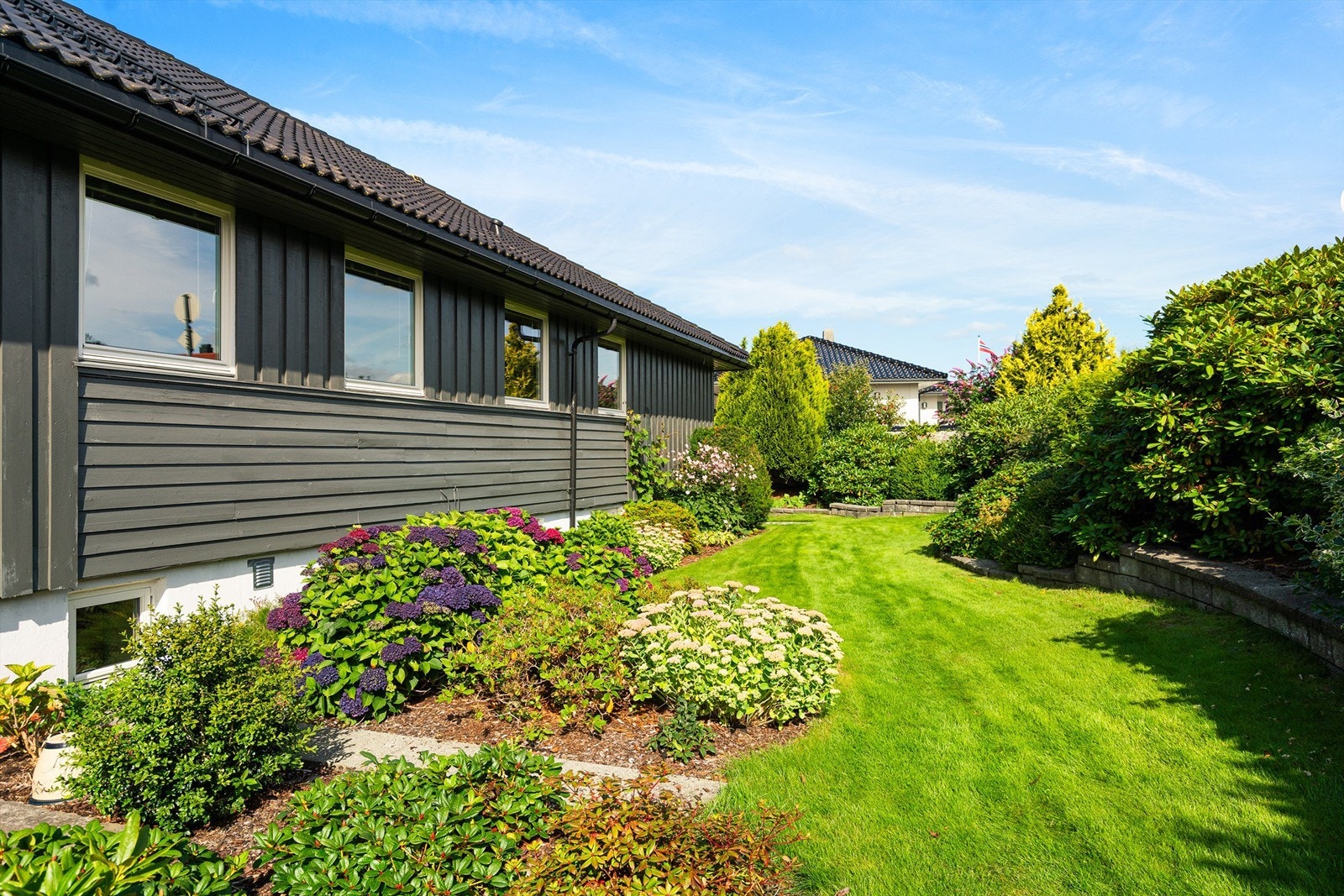 Forstøtningsmurer i stein rammer inn hagen. Galleribilde