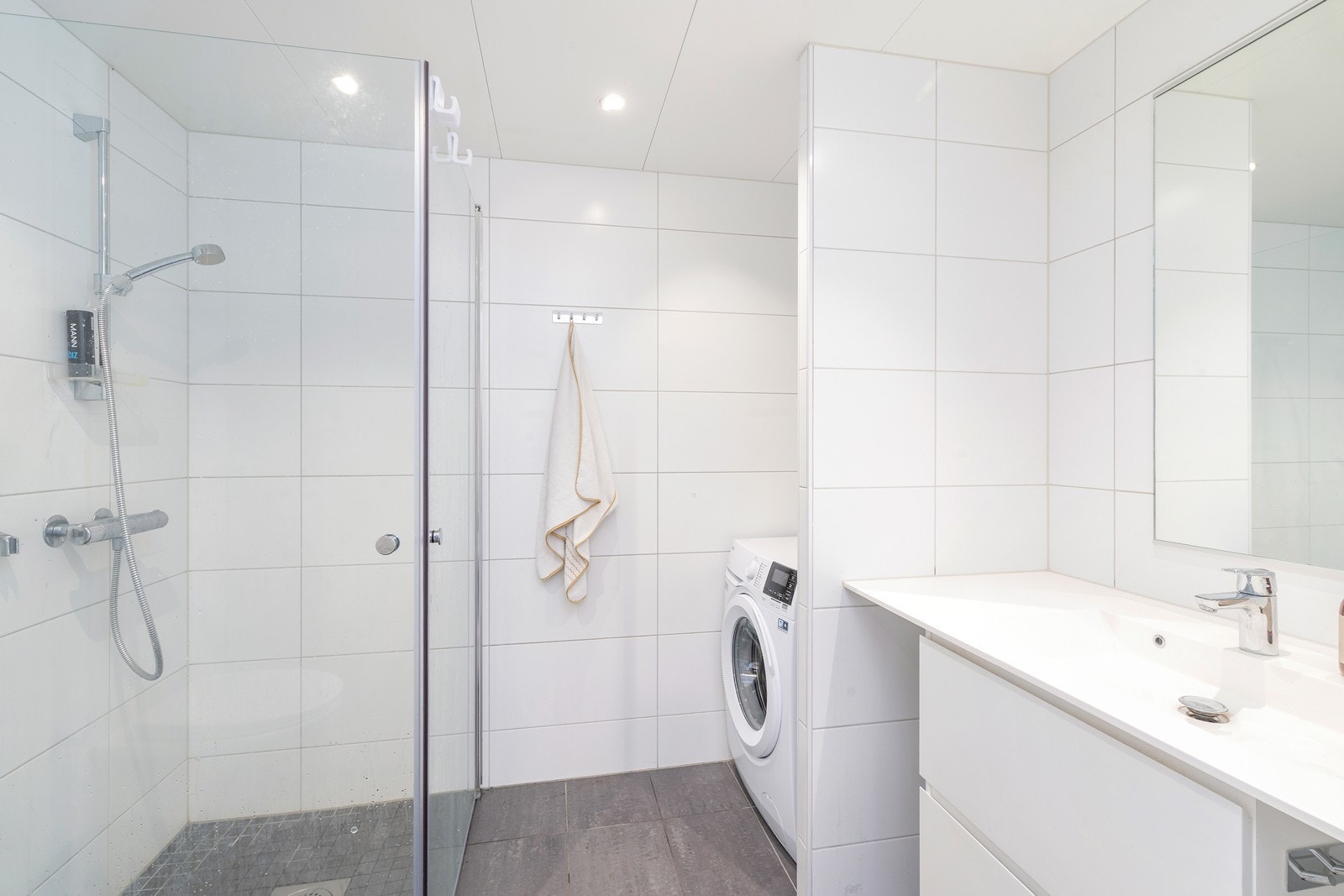 Badet ligger også tilknyttet gangen. Et romslig baderom med flotte flisvalg og opplegg for vaskemaskin/ tørketrommel. Galleribilde