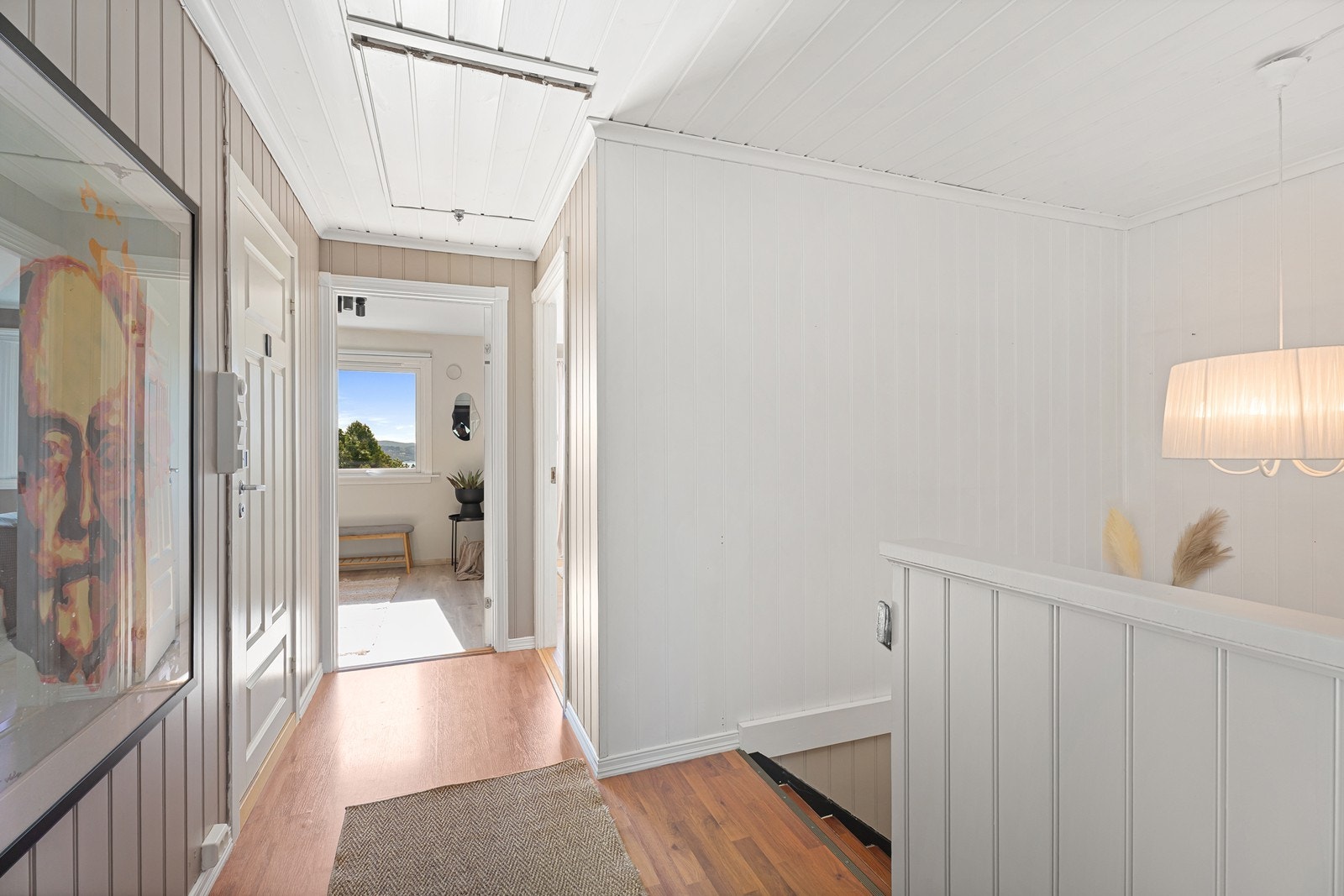Fra entréen leder trappen ned til underetasjen, mens bad og to av boligens soverom ligger videre inn i gangen. Galleribilde