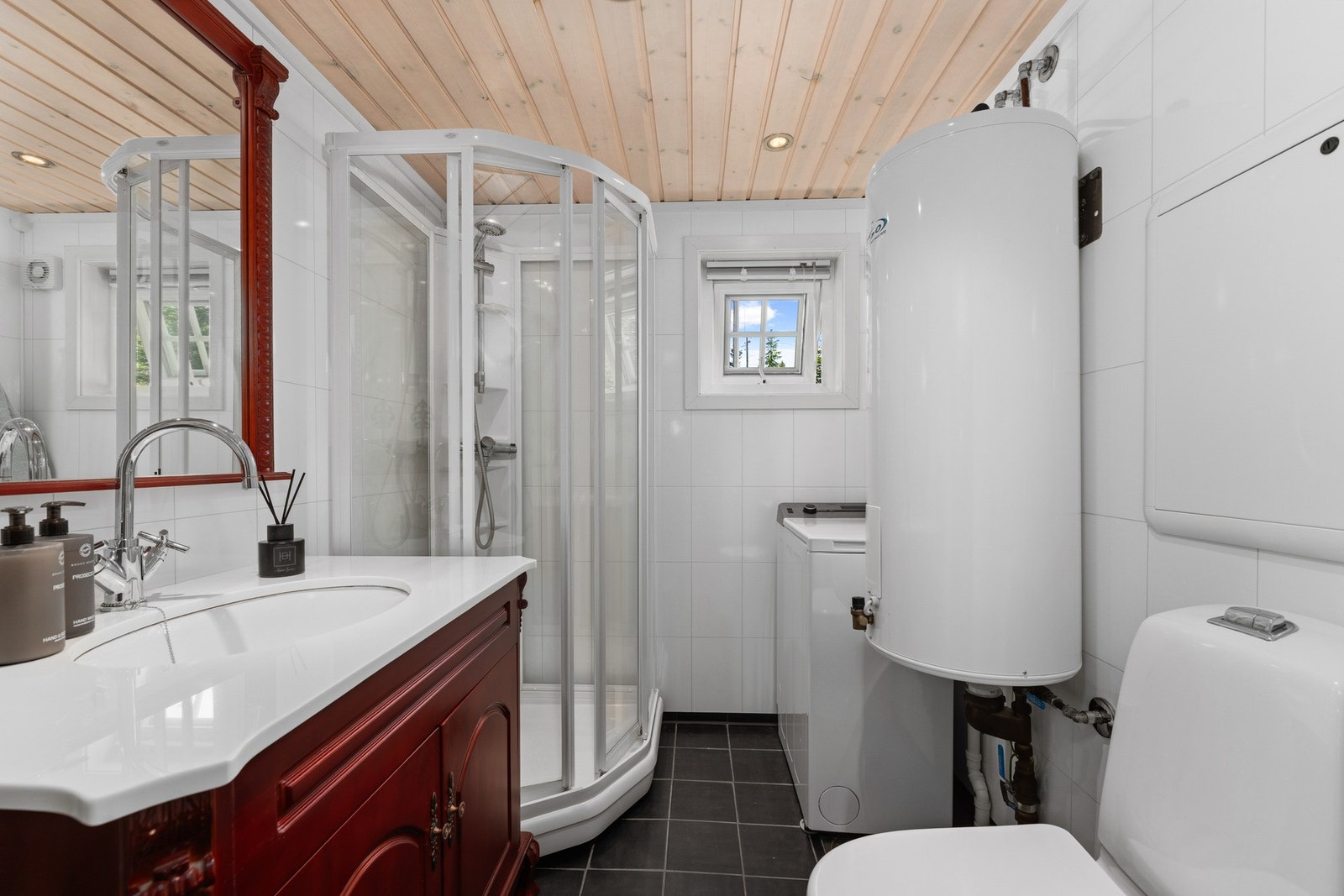 Badet fra 2013 har flislagt gulv med elektriske varmekabler, lyse baderomsplater på veggene og panel i himlingen Galleribilde