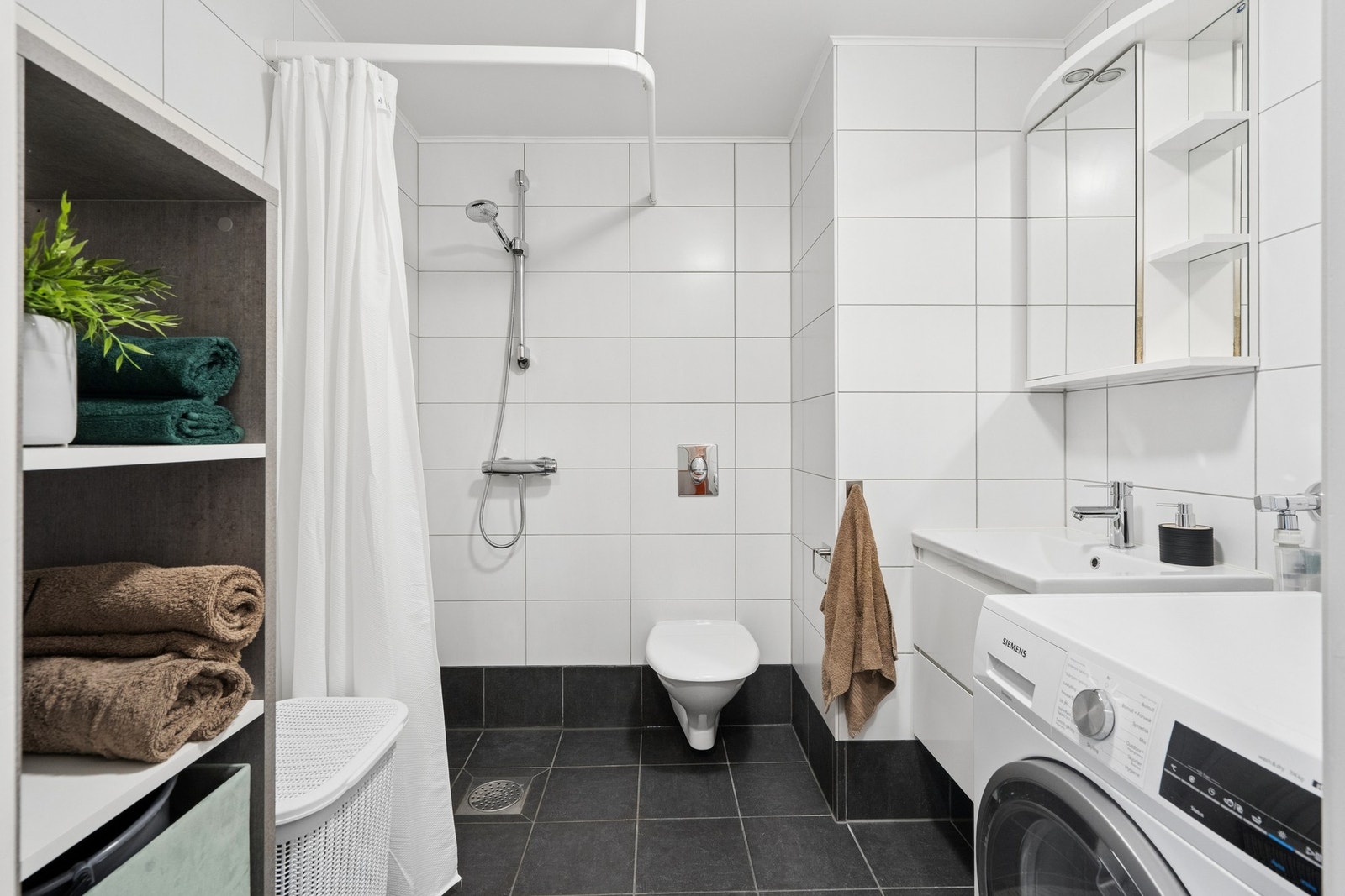 Flislagt bad med behagelig, vannbåren gulvvarme og opplegg for vaskemaskin. Galleribilde