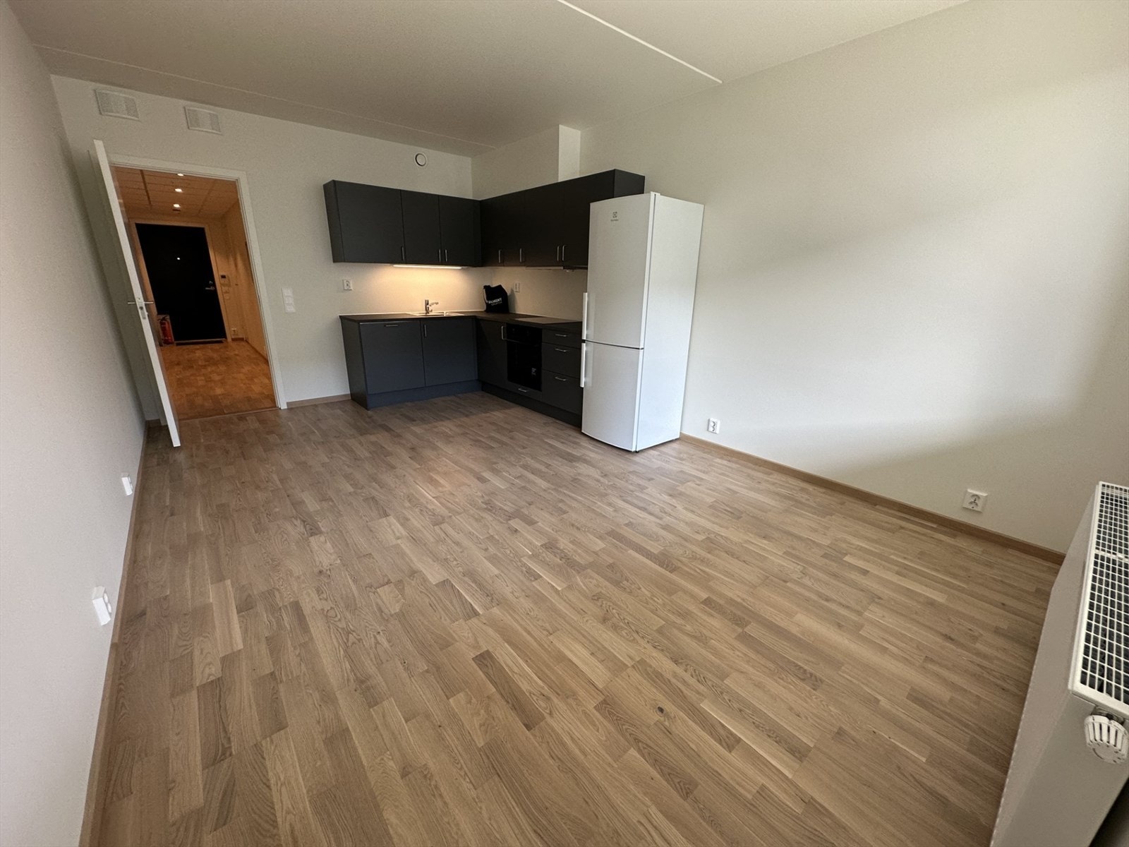 Åpen stue/kjøkkenløsning, med delikate mørke flater. Leiligheten har parkettgulv i stue/kjøkken, gang og soverom. Galleribilde