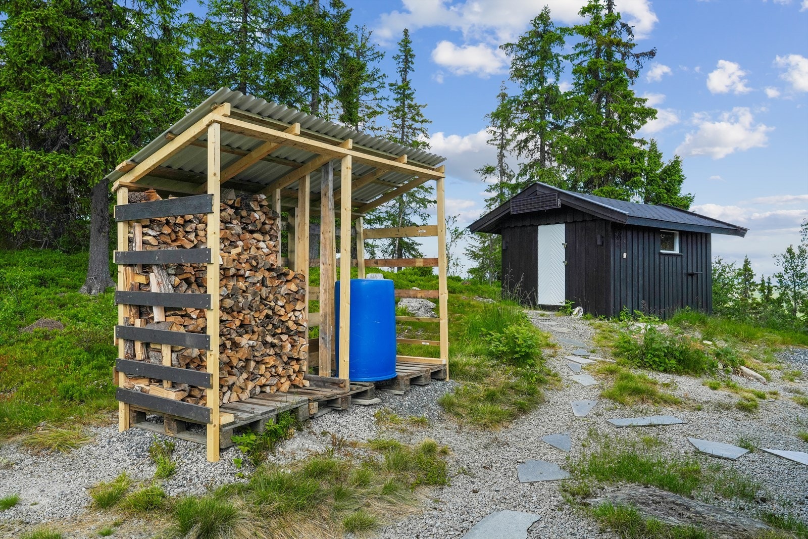 På tunet er det også et enkelt, åpent vedskjul. Galleribilde