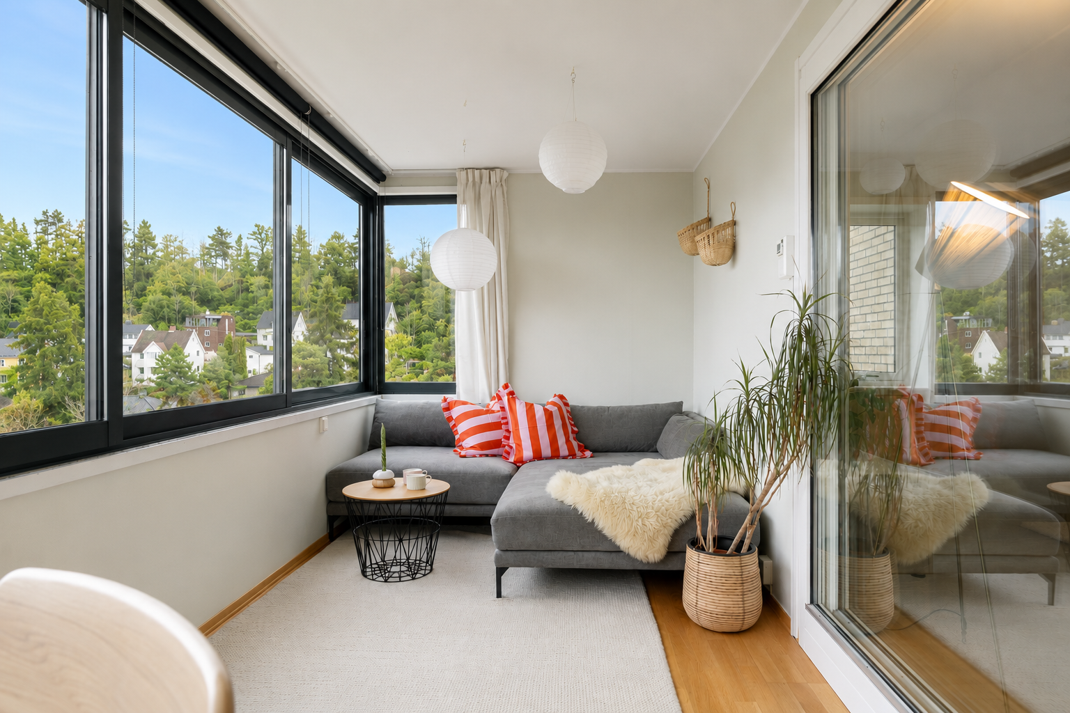 Leiligheten ligger flott til i byggets 4. etasje og har en smart planløsning med gode lysforhold. Foto: Pontus Holmenäs. NB! Bilde er tatt på høsten og er senere KI redigert for å illustrere hvordan utsikten er på sommerstid. Avvik kan forekomme. Galleribilde