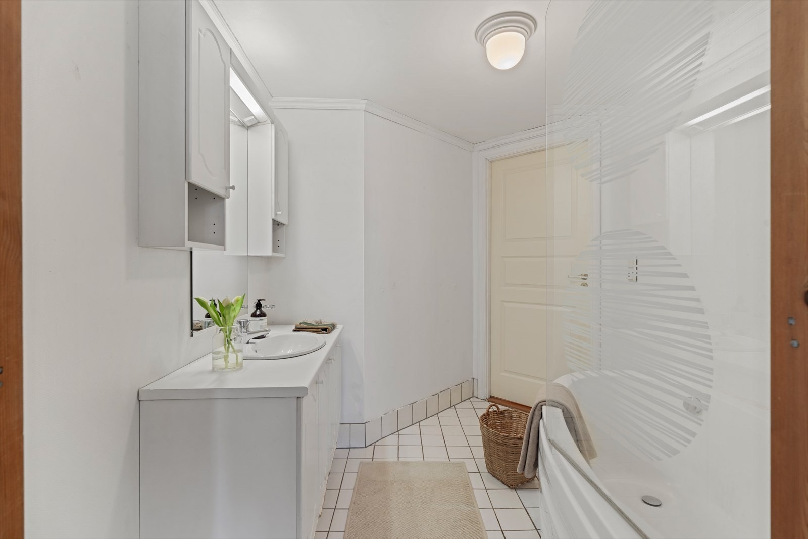 Badet er innredet med badekar og servant med underskap for oppbevaring. Galleribilde