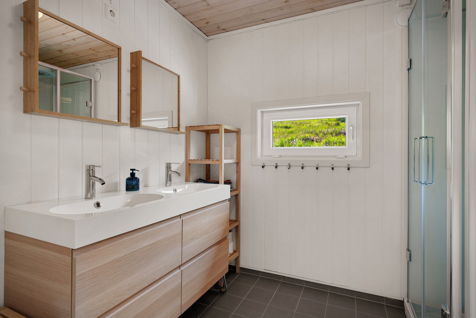 Badet er lagt med keramiske fliser på gulv og smartpanel på vegger Galleribilde