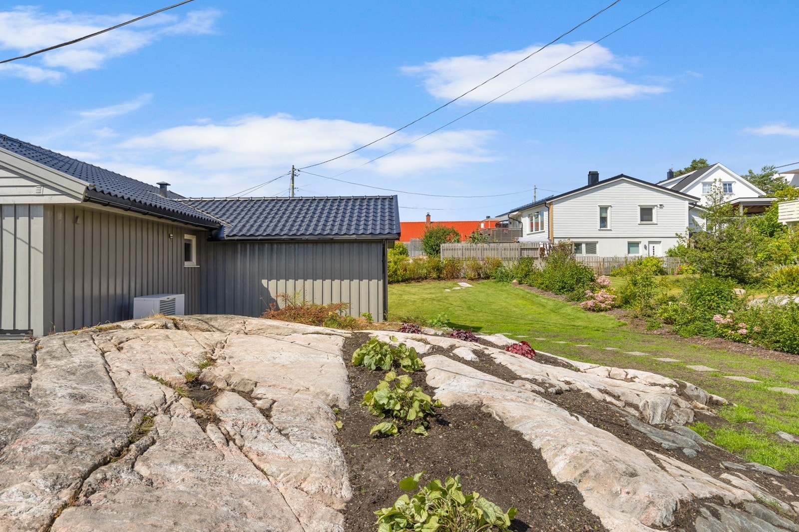 Naturlige fjellpartier er en del av tomten og skaper et fint uttrykk sammen med beplantningen. Galleribilde