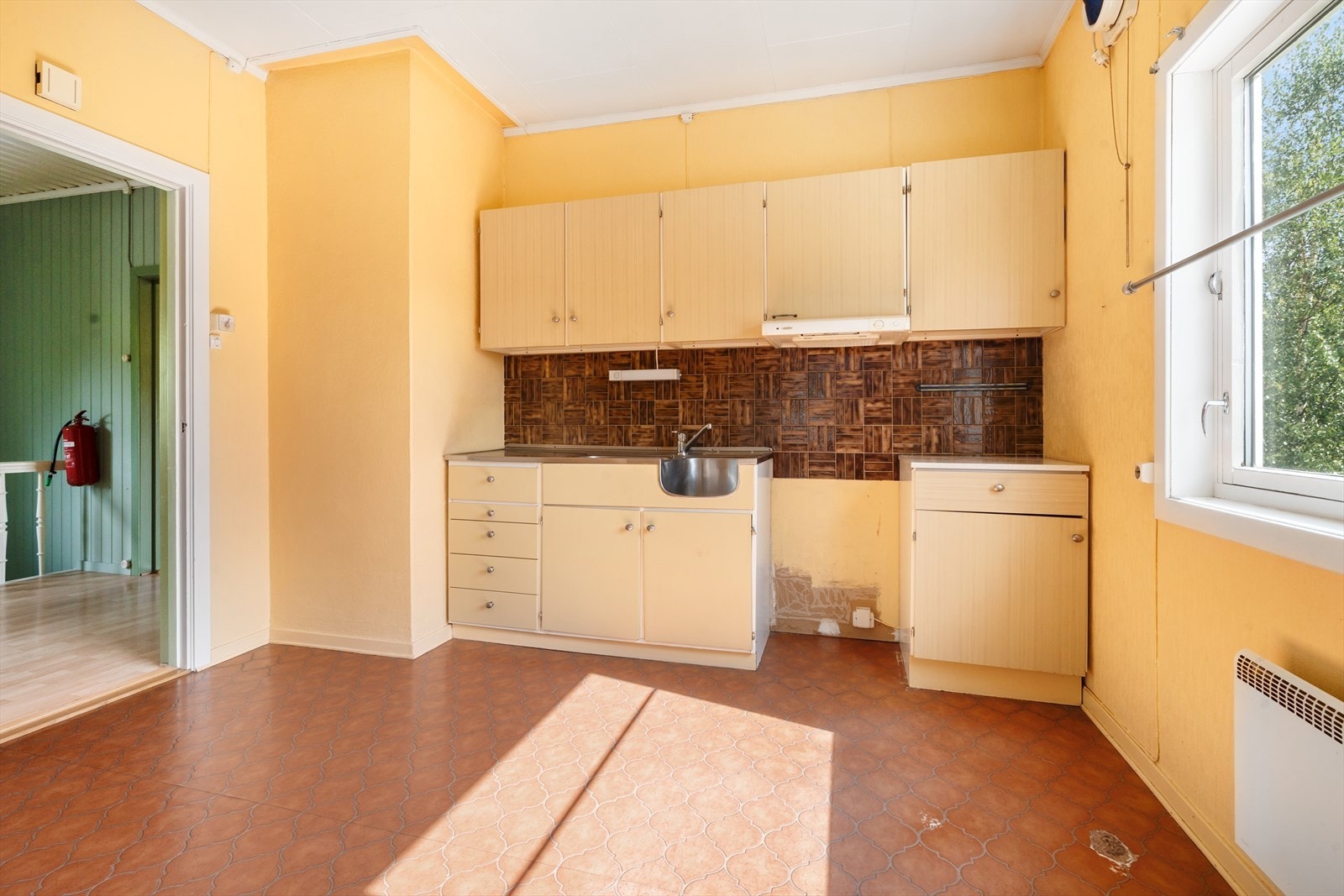 Eldre kjøkkeninnredning med god skap- og benkeplass. Et rom med potensial. Galleribilde